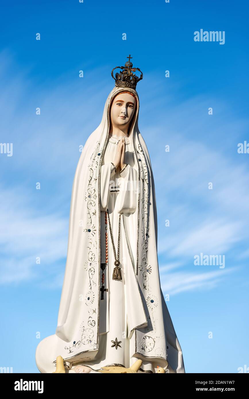 Closeup of a statue of Statue of Virgin Mary, mother of Jesus Christ, with crown and rosary on