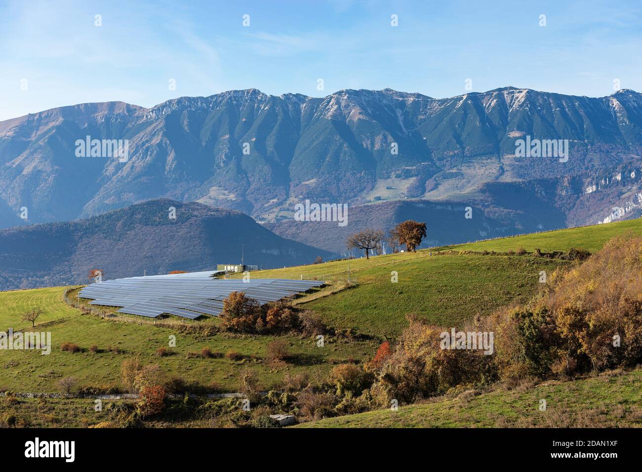 Solar power station in Italian Alps with many solar panels, Lessinia Plateau with the Mountain range of Monte Baldo. Italy. Renewable Energy concept. Stock Photo
