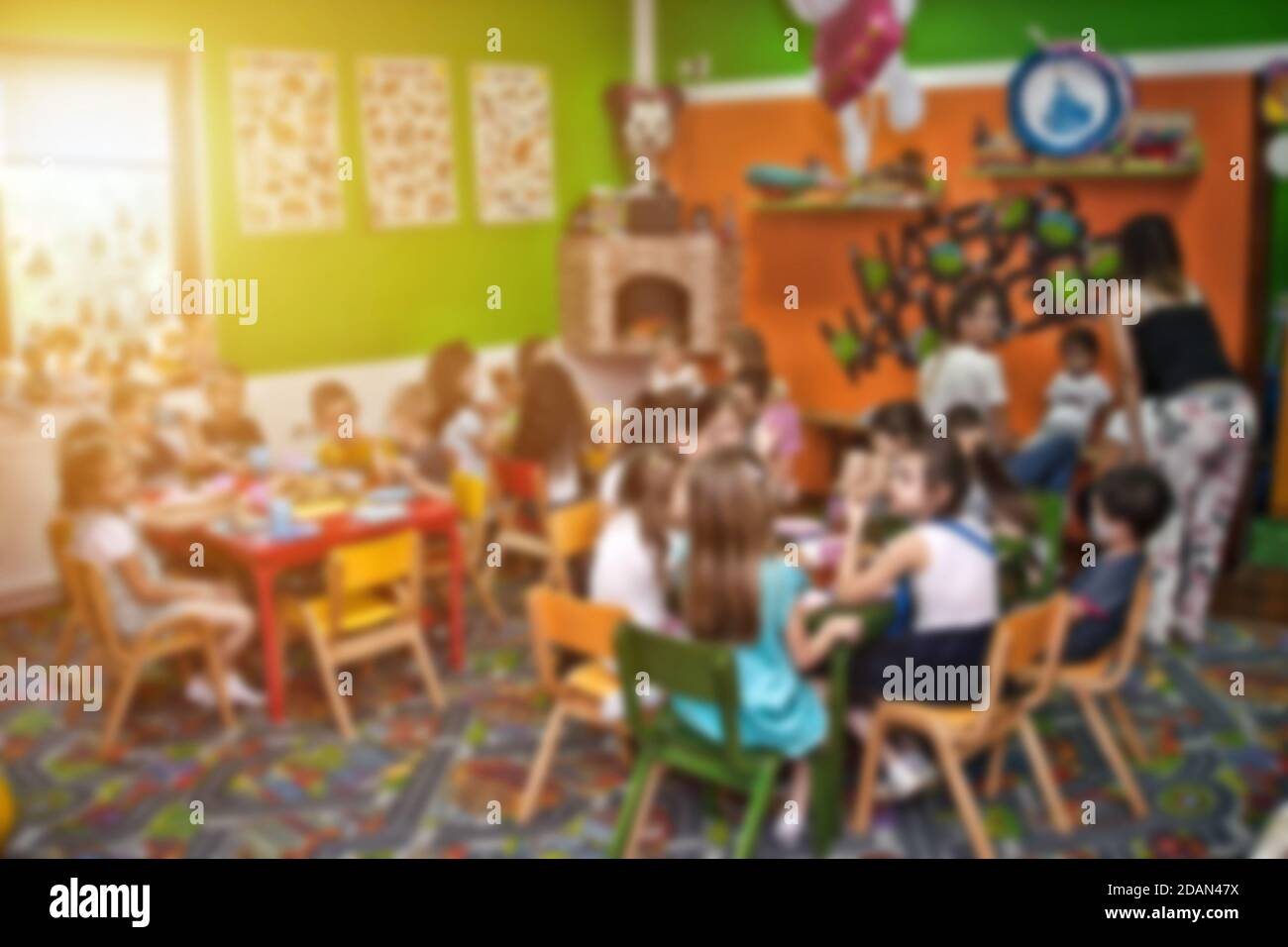 Blurred image of kids and their female tutor at birthday party for background usage. Stock Photo