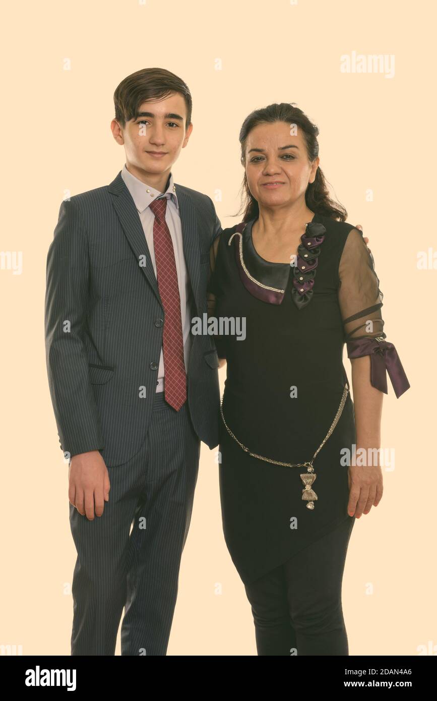 Studio shot of happy young Persian teenage businessman and mature