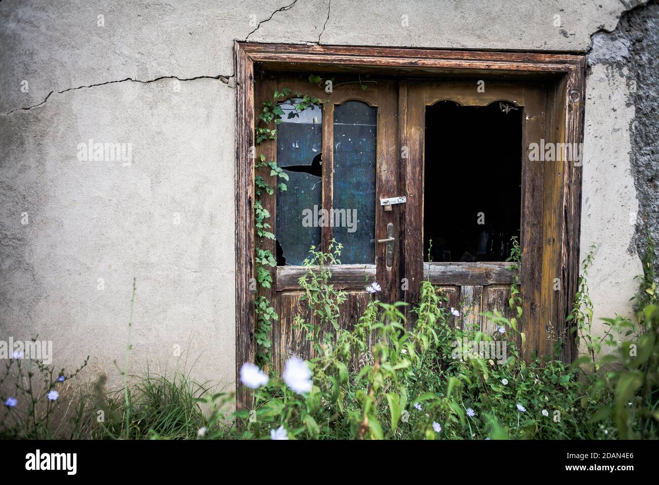 Doors with broken glass of an abandoned house in Serbian village. Stock Photo