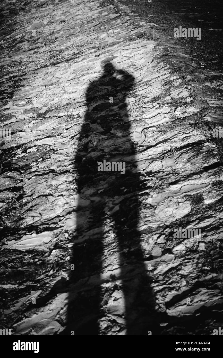 Self portrait of photographer's shadow with camera in hands. High