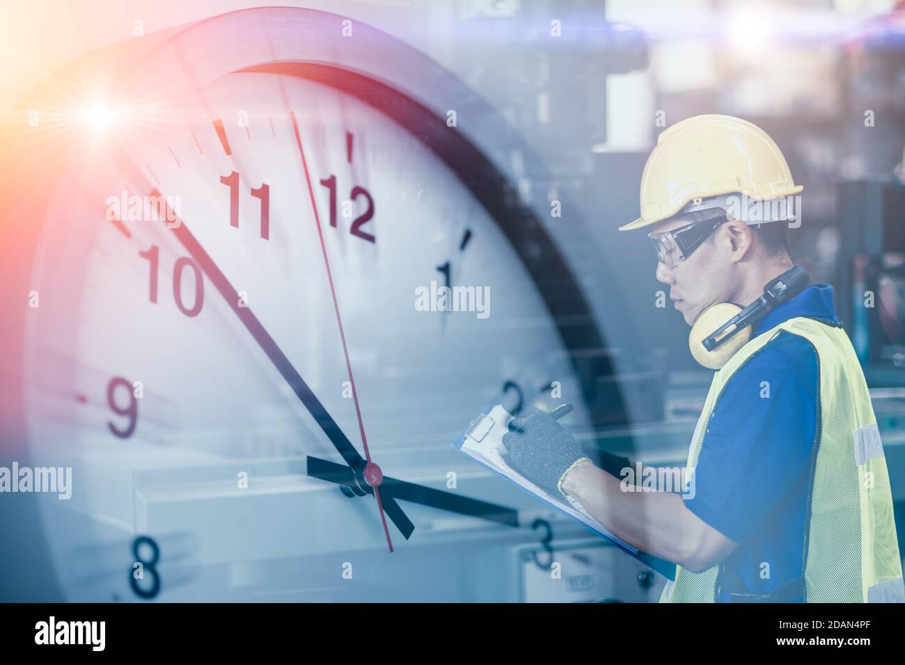 Engineer worker looking service check list in factory overlay with time clock for working hours concept. Stock Photo