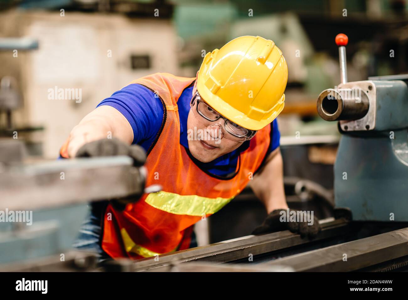 Asian worker work hard eyes focused on machine, people pay attention working in industrial plants. Stock Photo