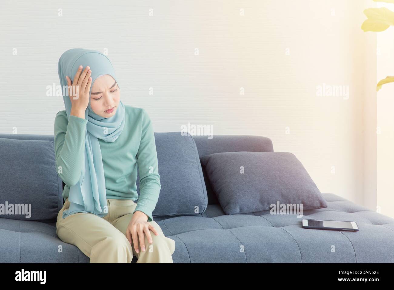 Arab Muslim Asian woman headache feel sick from using tablet. Stock Photo