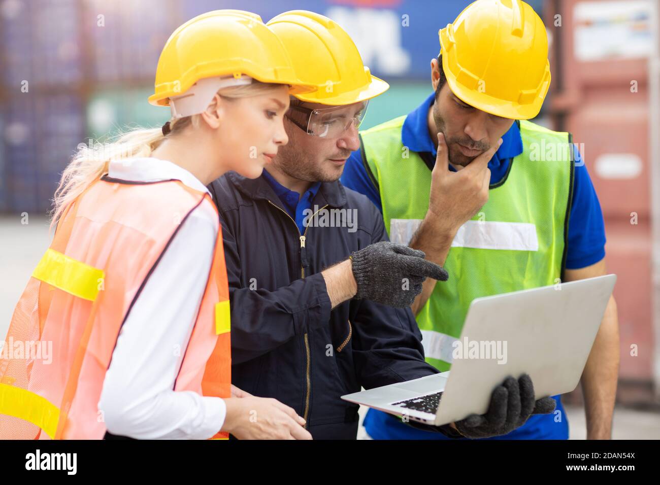 Logistic team worker working together to brainstorming analysis the problem report from laptop computer at port warehouse cargo shipping area. Stock Photo