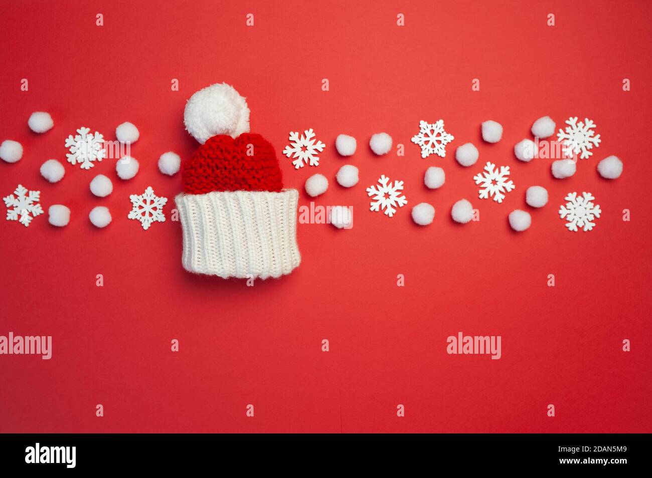 Christmas greeting card with red hat and snowflakes on red backgroun. Xmas holiday postcard with place for your text. Happy New Year Stock Photo