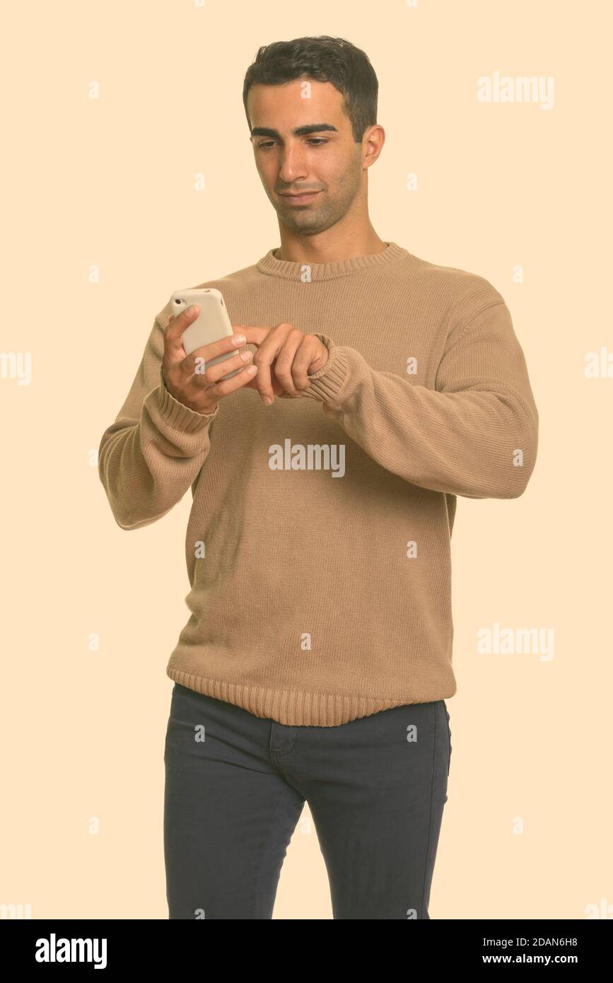 Young handsome Iranian man using mobile phone Stock Photo