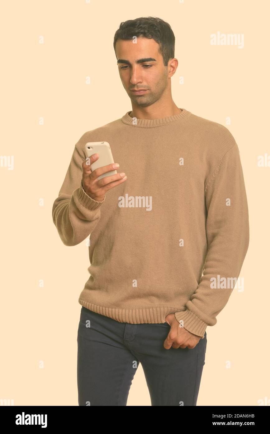 Young handsome Iranian man using mobile phone Stock Photo
