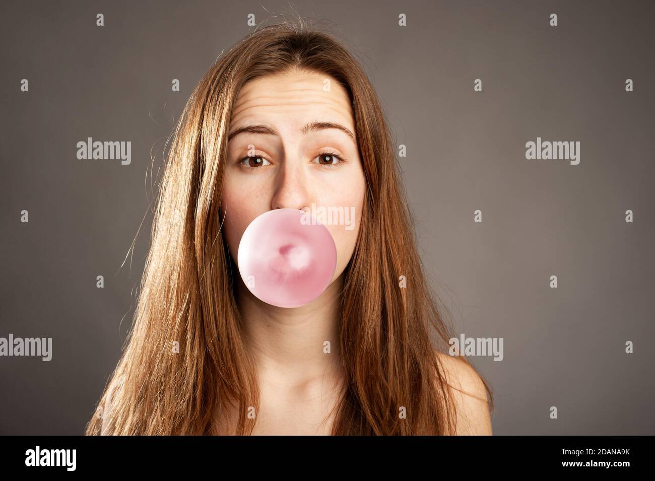 young woman making a bubble from a chewing gum Stock Photo Alamy