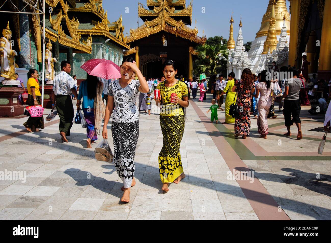 Burmese families walking around the beautiful scared grounds of the Shwedagon Pagoda in Yangon Myanmar Stock Photo