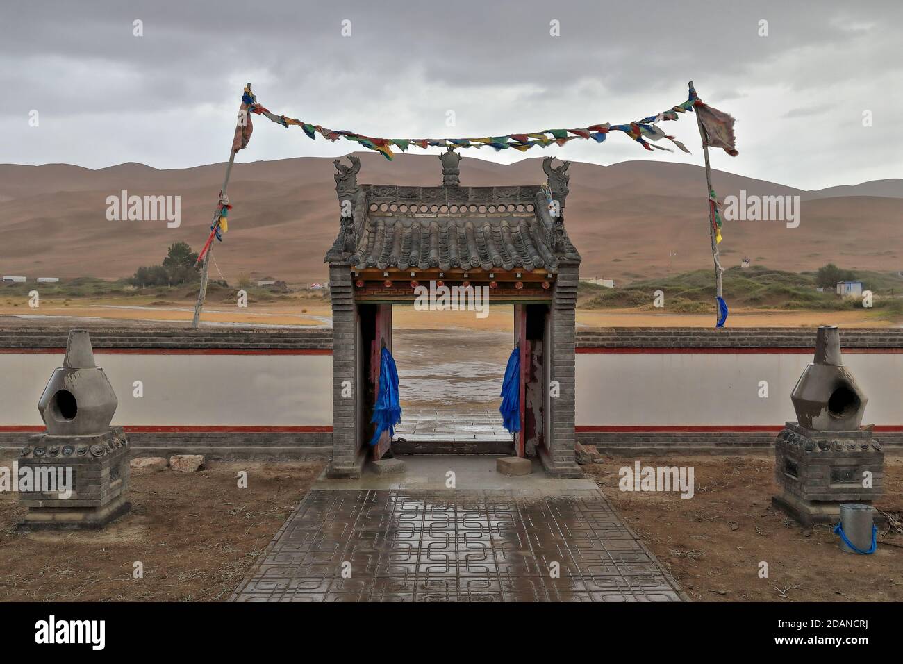 Entrance archway-Buddhist prayer flags-Badain Jaran Desert Temple. Inner Mongolia-China-1116 Stock Photo