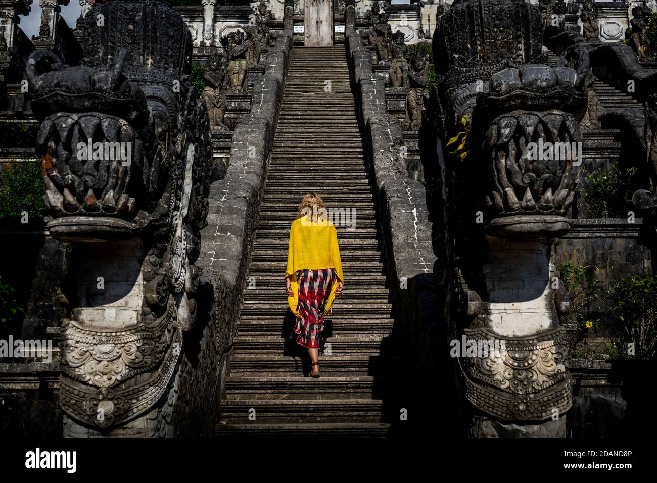 young woman walks up the stairs to temple Stock Photo