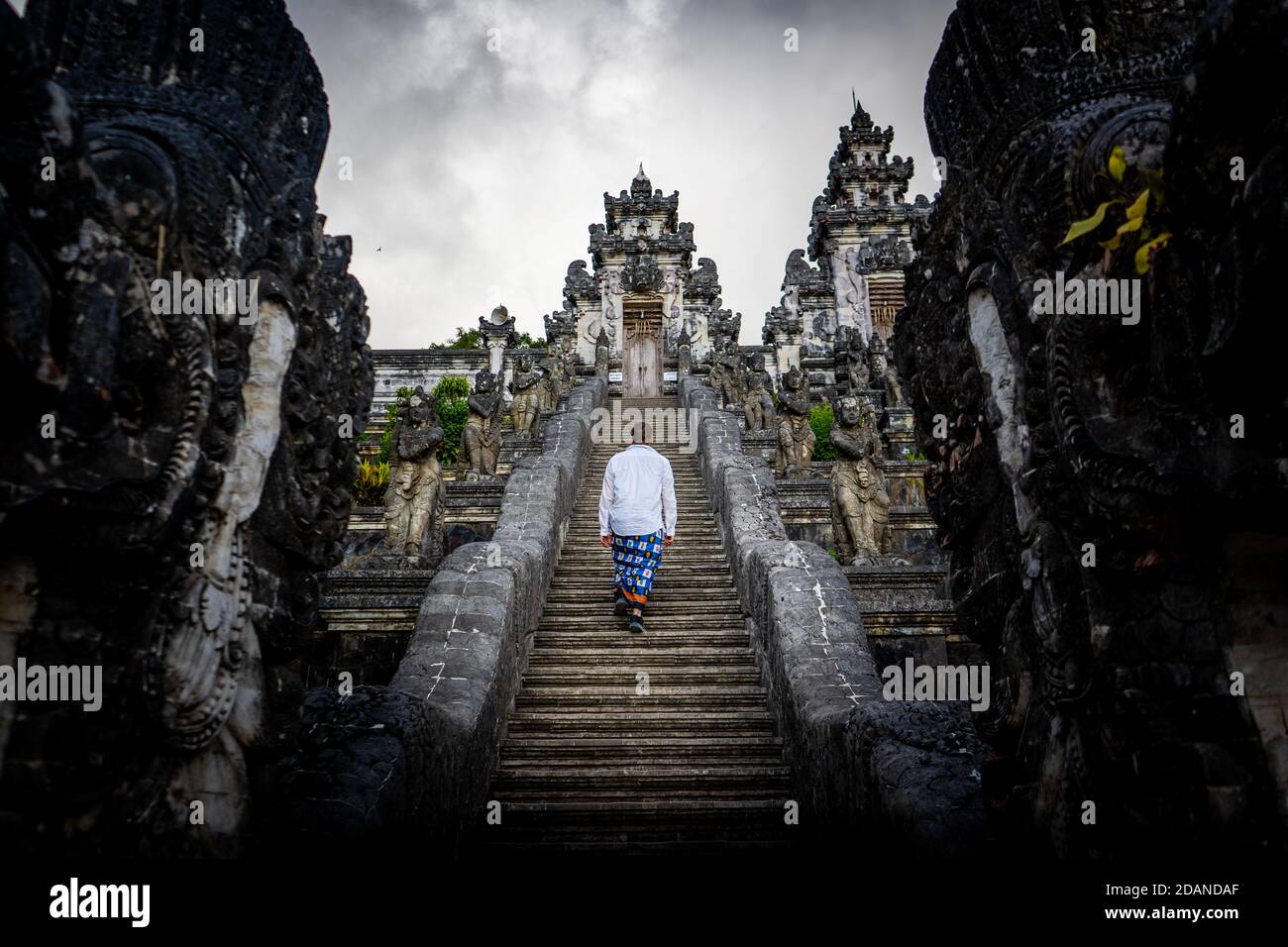 man goes up the stairs to temple Stock Photo
