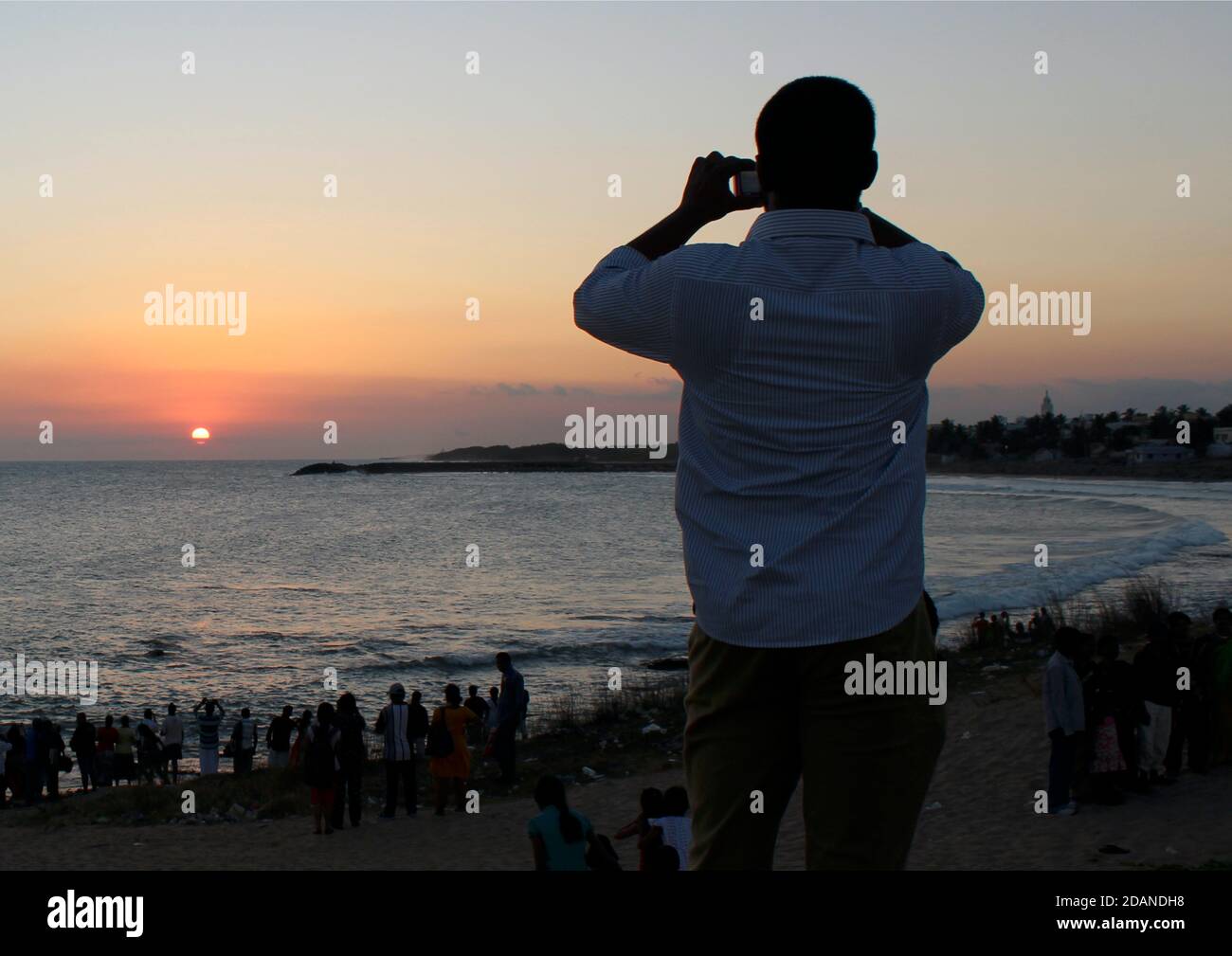 Indian gentleman at Kanyakumari taking a photograph of the sunset. Stock Photo