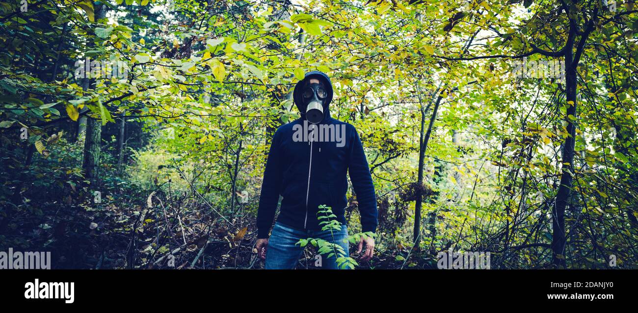 Man with gas mask in forest at autumn Stock Photo