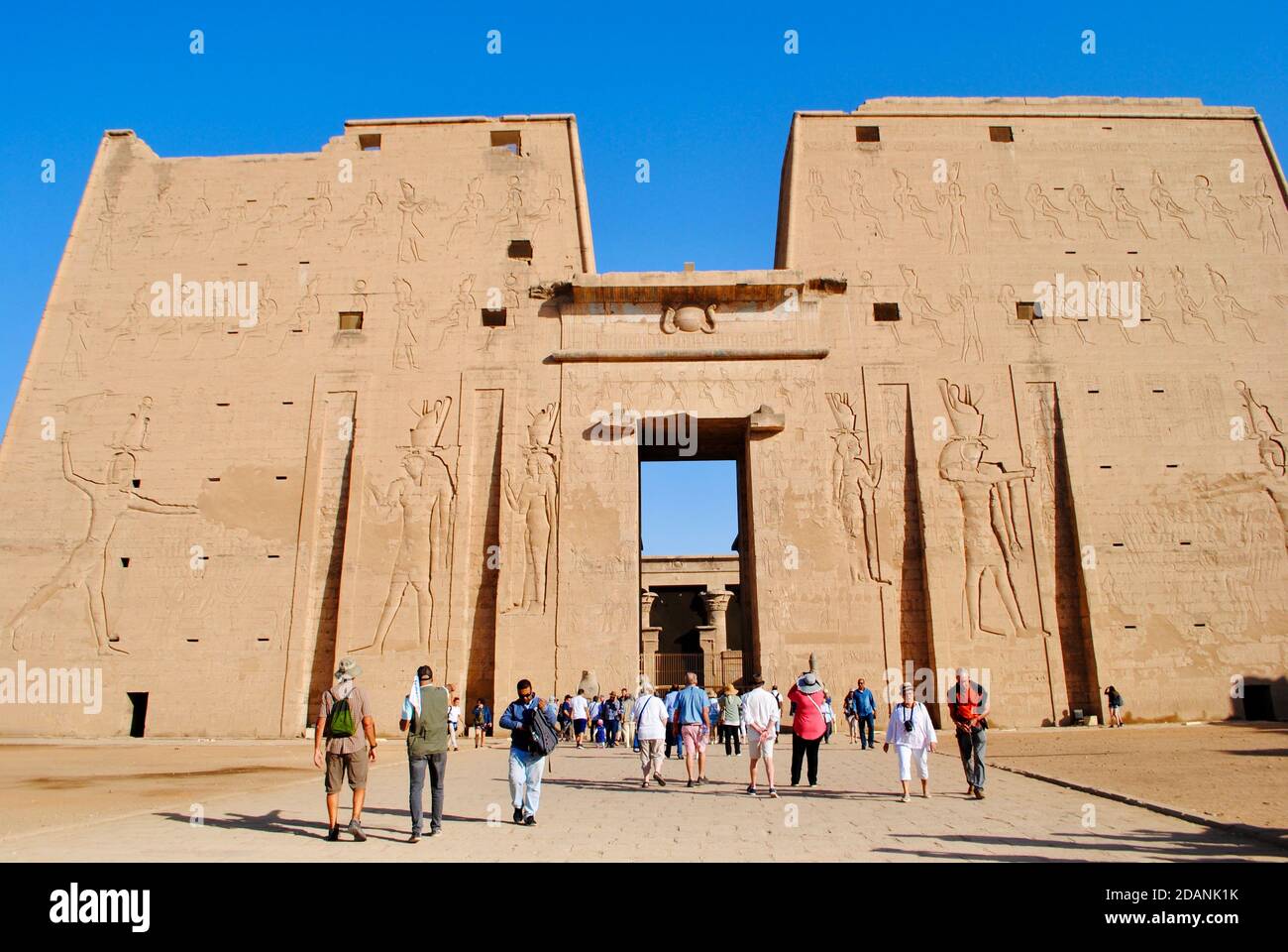 Aswan Egypt. Tourists at the entrance of The Temple of Horus, Sky God at Edfu. West bank of the Nile, Upper Egypt. Stock Photo
