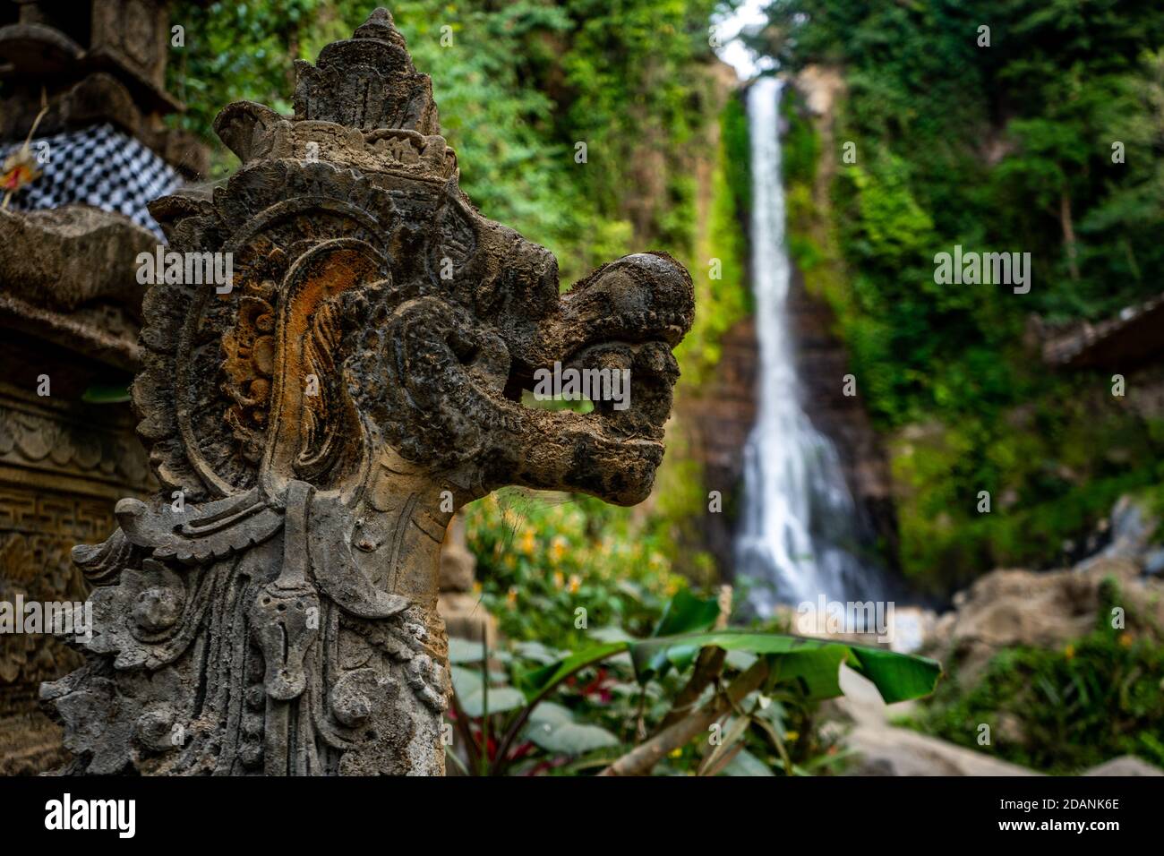 stone dragon sculpture and waterfall in background Stock Photo