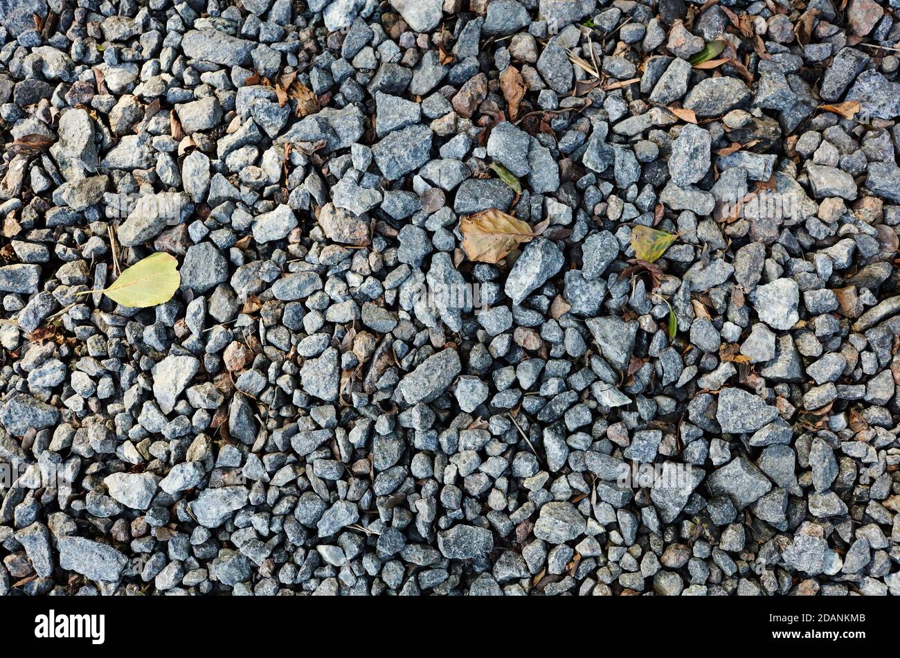 Grey ground stone rubble road background. Natural gray granite chippings, macadam, rubble or crushed stones texture, top view Stock Photo