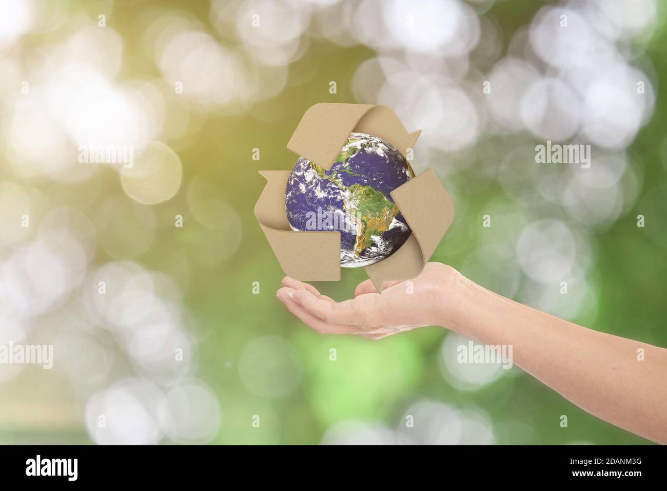 World earth day concept. Man show outstretched hand with Earth and recycle symbol on green bokeh background. Elements of this image furnished by NASA Stock Photo