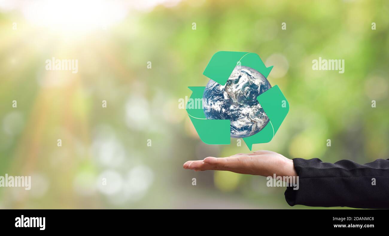 Environment concept. Earth and recycle in hand over green background. Elements of this image furnished by NASA Stock Photo