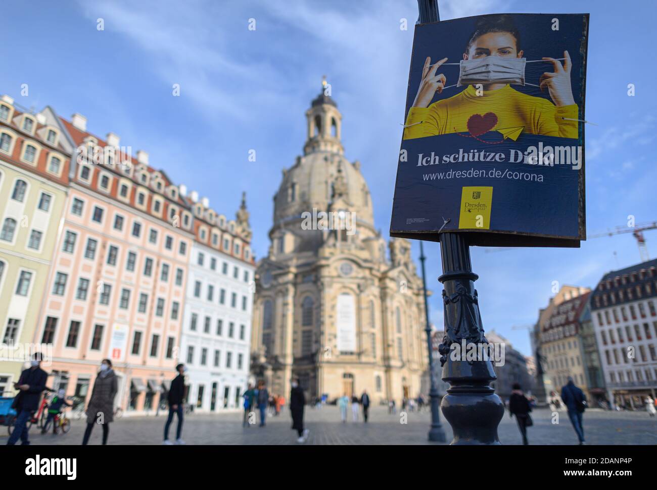 Dresden, Germany. 14th Nov, 2020. The official poster of the state capital Dresden, which points out the use of mouth-nose masks, hangs on a lantern on the Neumarkt in front of the Frauenkirche. The federal and state governments have decided on a partial lockdown. Among other things, restaurants, leisure facilities and cultural institutions will have to close. This continues to include the distance requirement and the obligation to wear masks. Credit: Robert Michael/dpa-Zentralbild/dpa/Alamy Live News Stock Photo