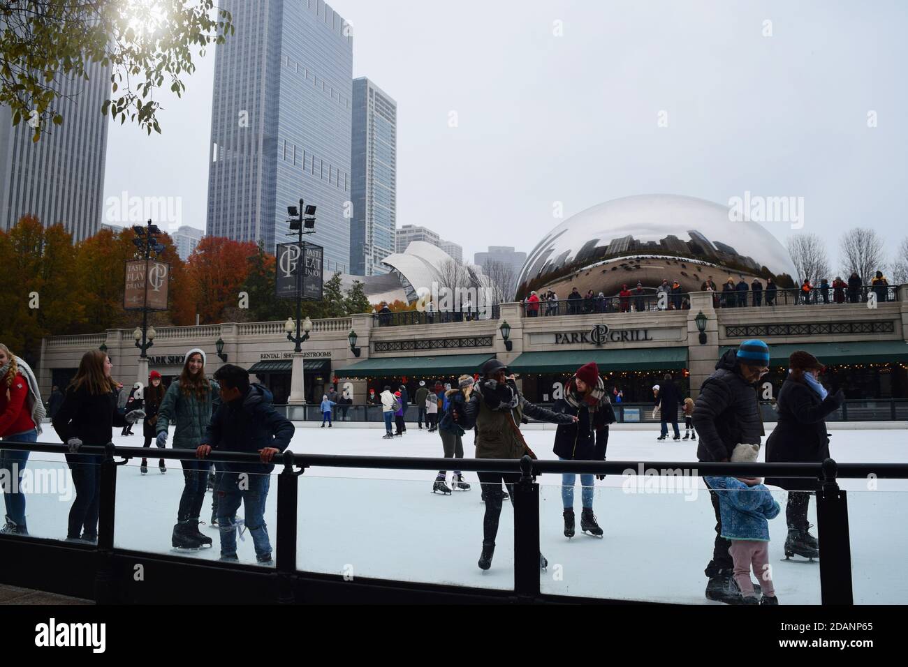 People iceskating in downtown Chicago on a cloudy winter day with