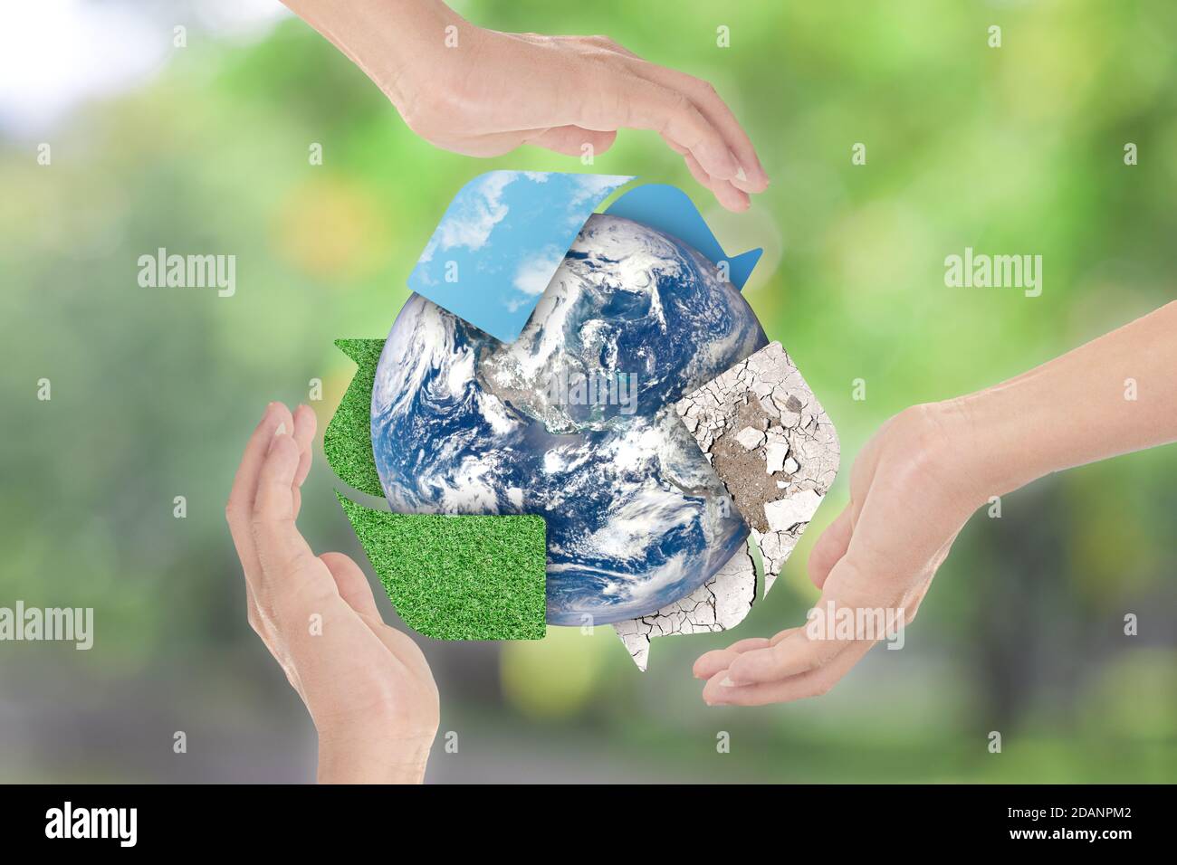 Recycle symbol and Earth in hands over green nature background. Environment concept. Elements of this image furnished by NASA Stock Photo