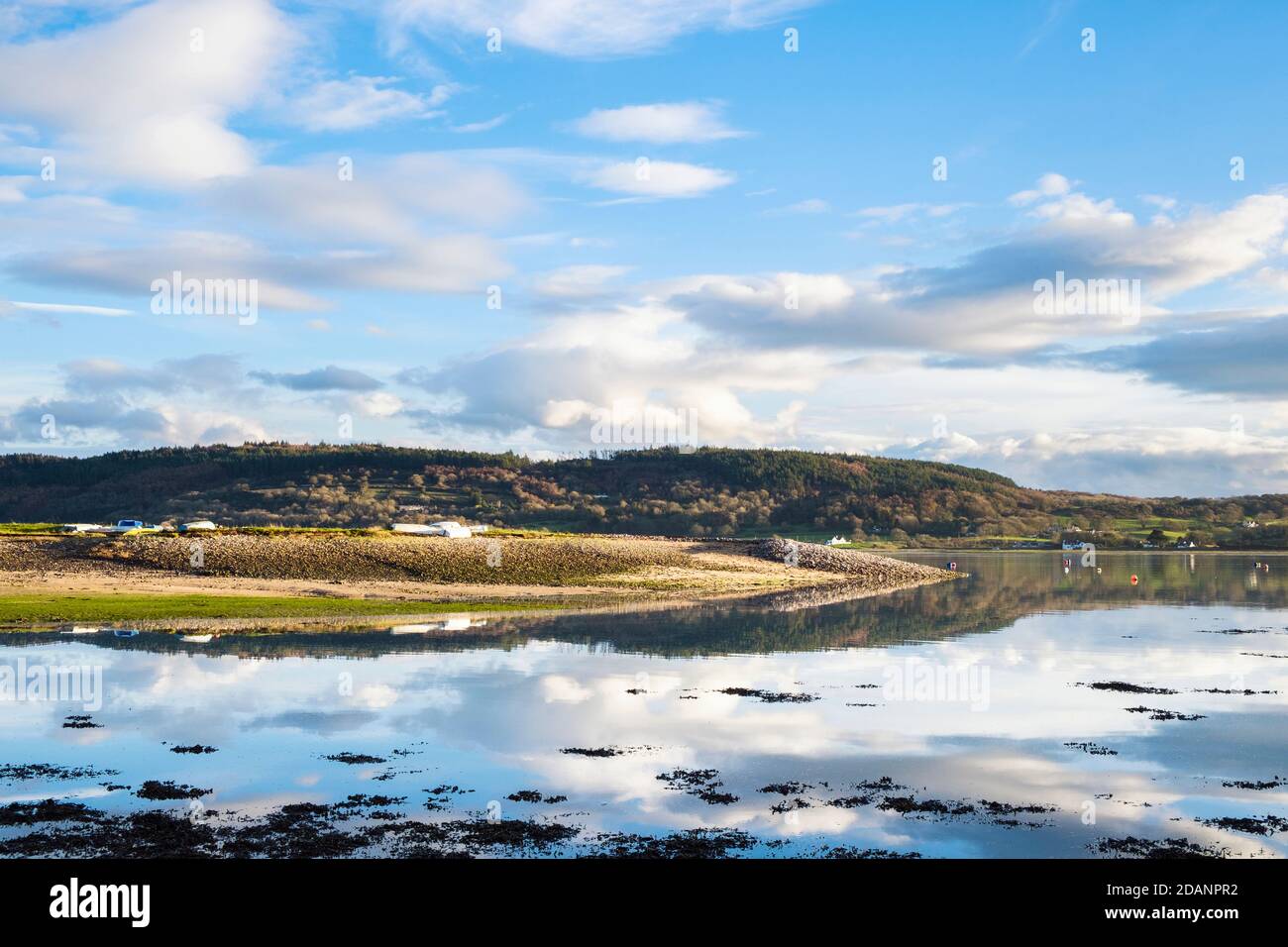 Tranquil scene with clouds reflected in calm sea at high tide in Red Wharf Bay, Isle of Anglesey, Wales, UK, Britain Stock Photo