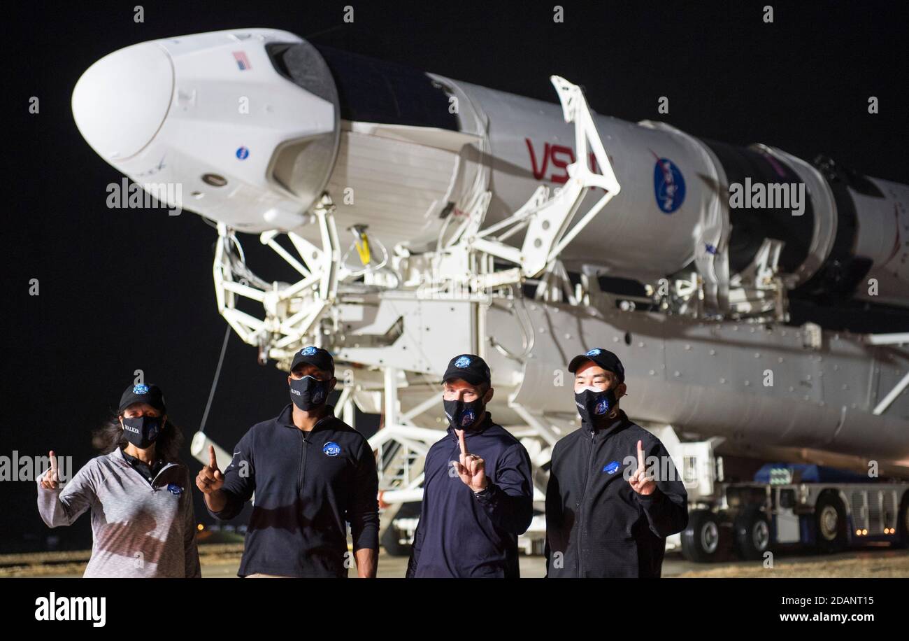 NASA astronauts pose as the SpaceX Falcon 9 rocket with the Crew Dragon Resilience onboard is rolled out to Launch Complex 39A at the Kennedy Space Center November 9, 2020 in Cape Canaveral, Florida. Standing from left to right are: Shannon Walker, Victor Glover, Mike Hopkins, and JAXA astronaut Soichi Noguchi. Stock Photo
