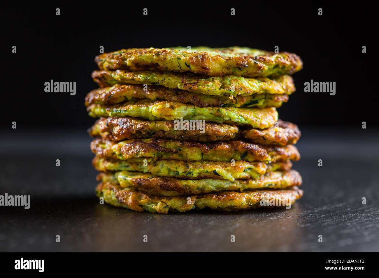 Zucchini pancakes on black background Stock Photo