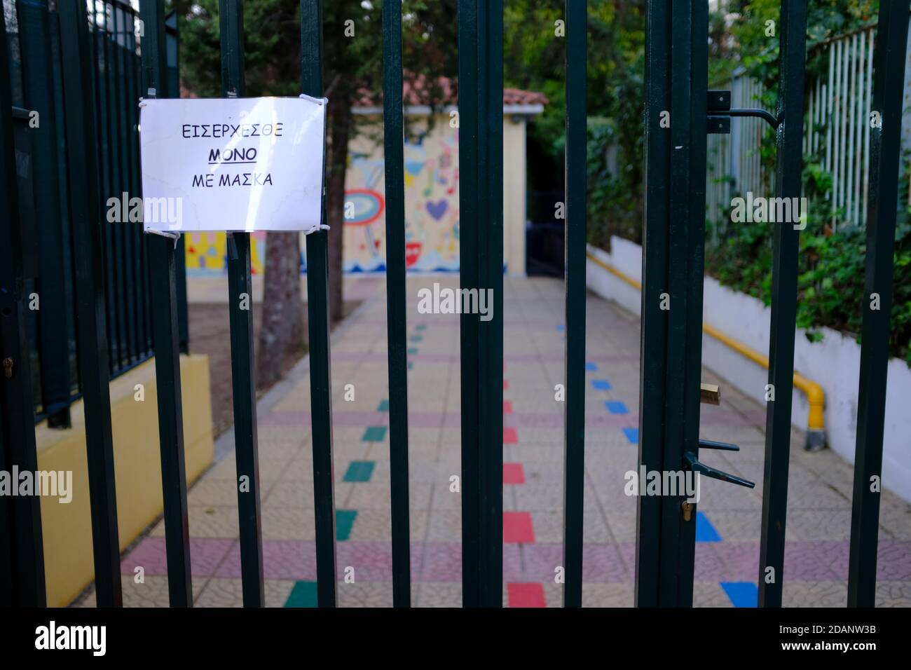 Athens Greece 14th Nov. 2020. A pre-school’s entrance locked, with a sign that reads “Enter only with a mask on”.Greece is in lockdown to stem the rapid spread of COVID-19. Credit: Michael Varaklas/Alamy Live News Stock Photo