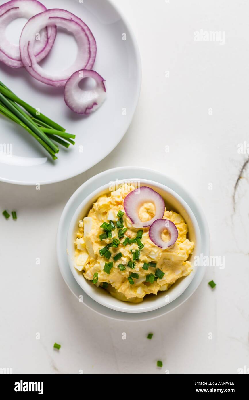 Egg spread with onion and chives on marble background Stock Photo