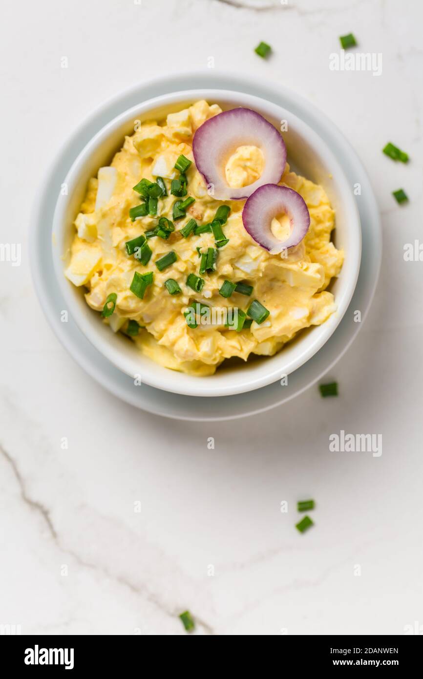 Egg spread with onion and chives on marble background Stock Photo