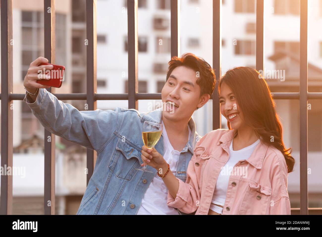 young happy couple lover and romantic at first date relationship. cute asian boyfriend using smartphone to selfie with her girlfriend at sweet dinner Stock Photo
