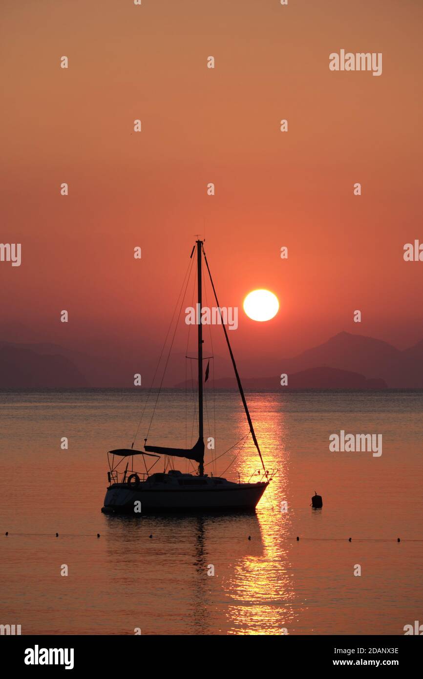 Silhouette of a boat and mountains at sunrise, Turunc, Turkey Stock Photo