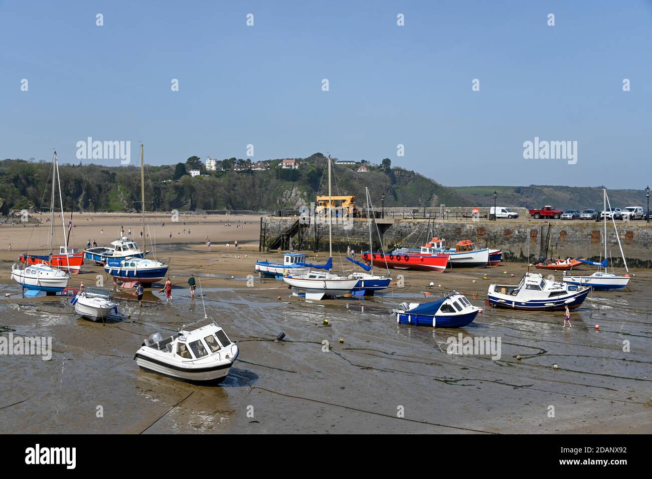 Tenby, Wales - April 15 2019 : The boats in Tenby Harbour at low tide showing the mooring lines. Stock Photo