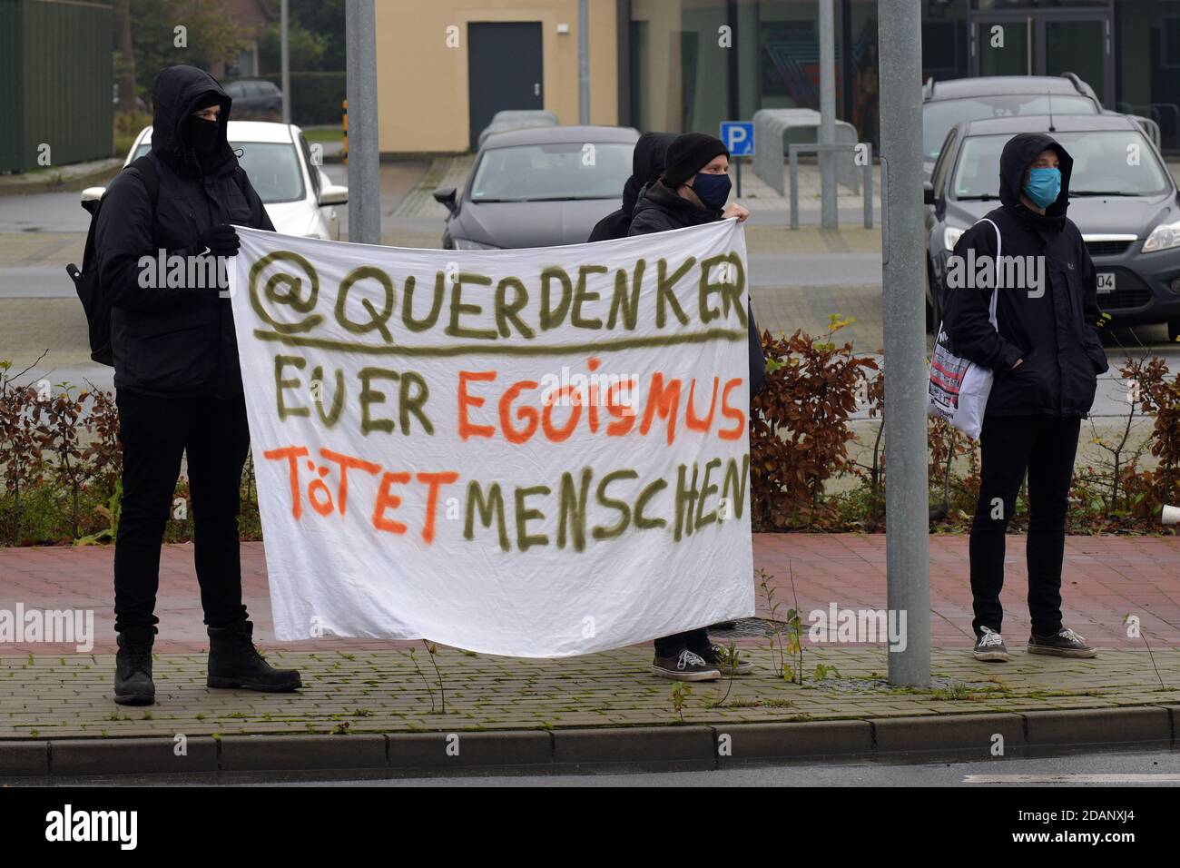 Aurich, Germany. 14th Nov, 2020. Counter-demonstrators hold a poster against the so-called 'lateral thinkers' with the inscription 'lateral thinkers your egoism kills people', while a lateral thinker demonstration passes them by. About 150 people protested against the demonstration of lateral thinkers. Credit: Michael Bahlo/dpa/Alamy Live News Stock Photo