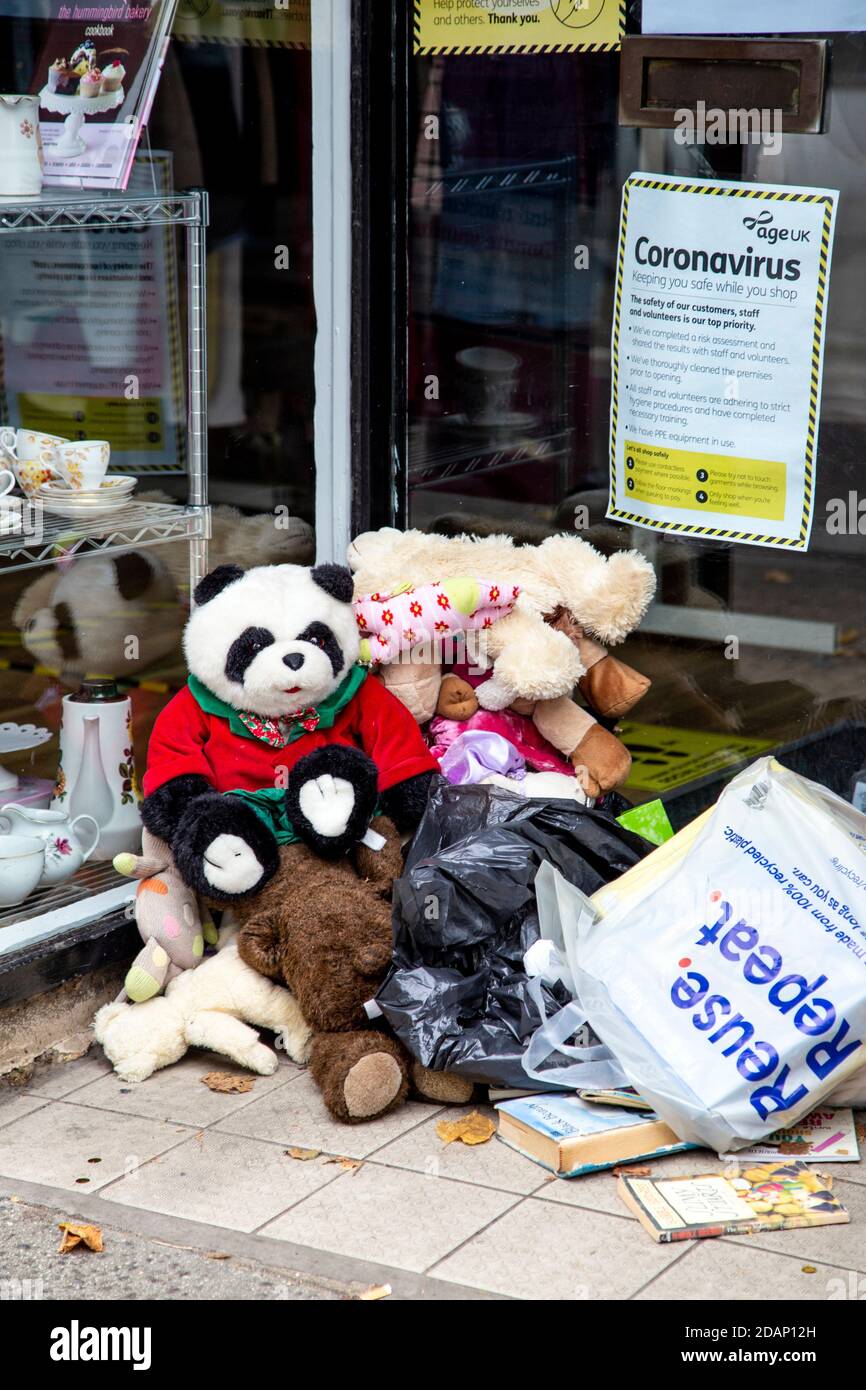 Piled up donation bags and toys outside Age UK charity shop in Rickmansworth, UK Stock Photo