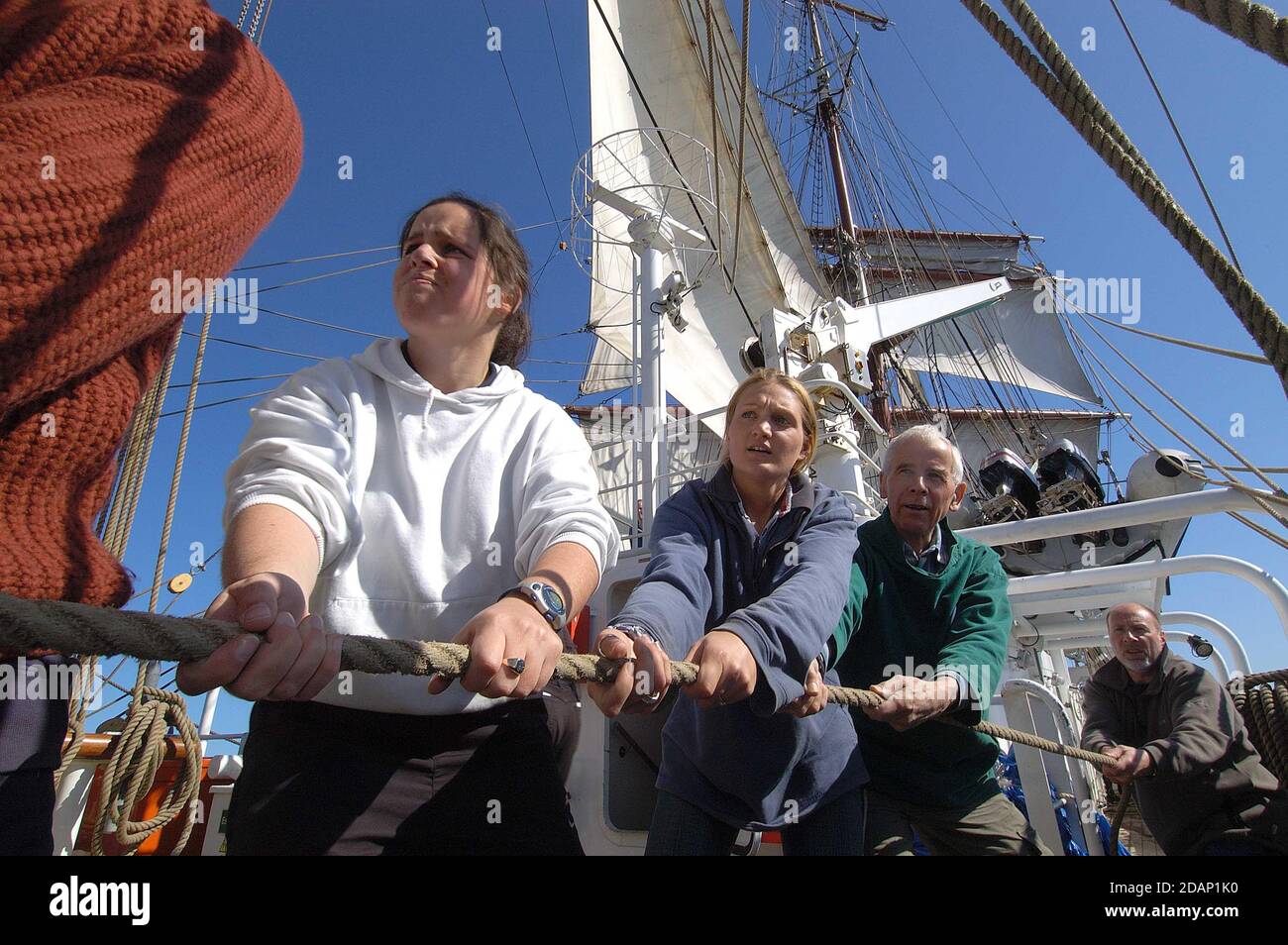 Crew hauling on the hemp rope sheets  on  a Tall ship   to  trim the yard; and  therefore adjust  the sails on a square-rigged sail ship Stock Photo