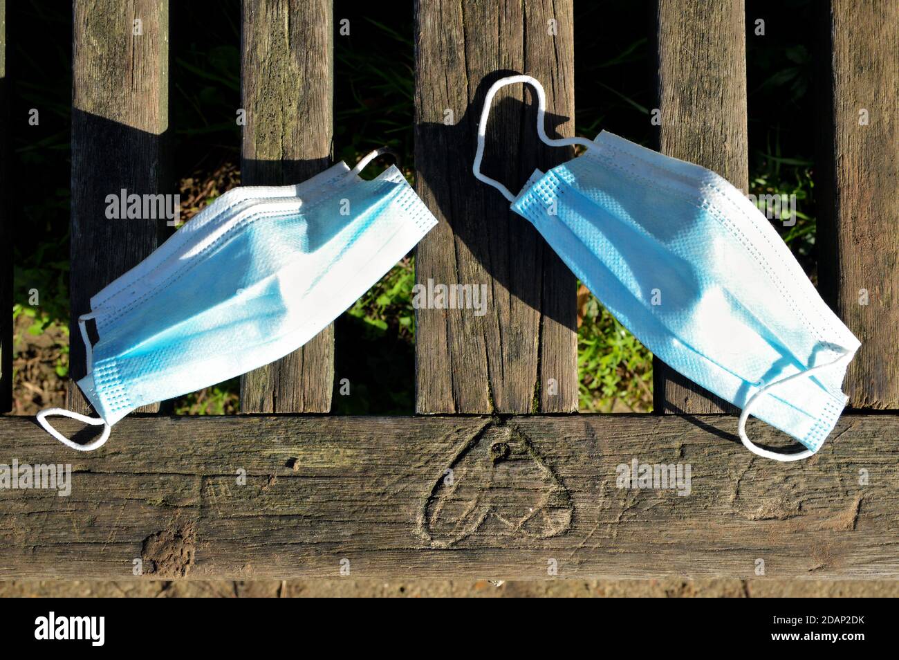 Two surgical masks of a couple next to a heart, symbolizing couple and love during a pandemic. Stock Photo