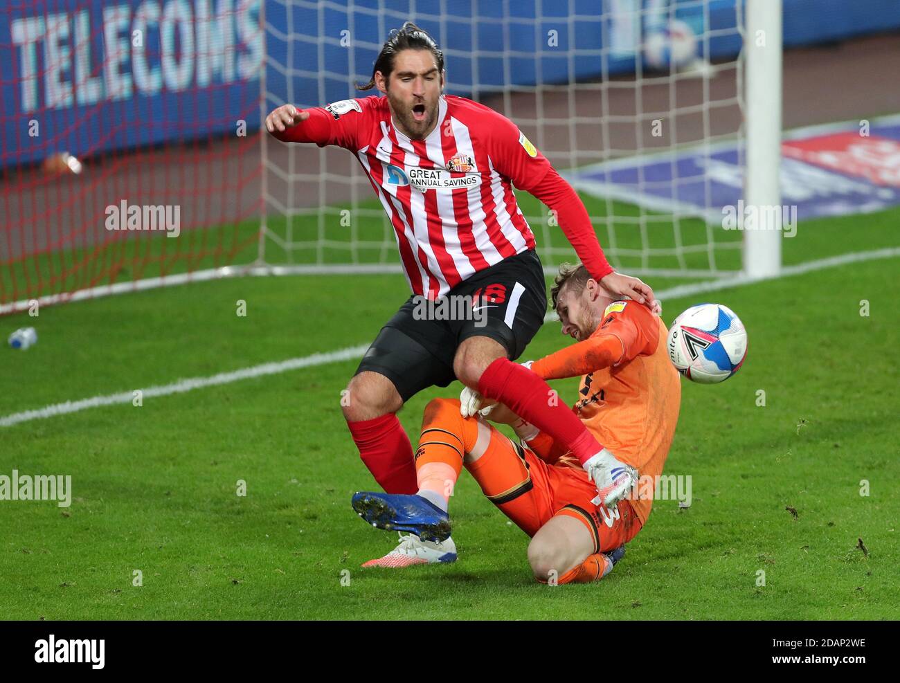 Sunderland's Danny Graham (left) and Milton Keynes Dons goalkeeper Andrew Fisher battle for the ball during the Sky Bet League One match at the Stadium of Light, Sunderland. Stock Photo