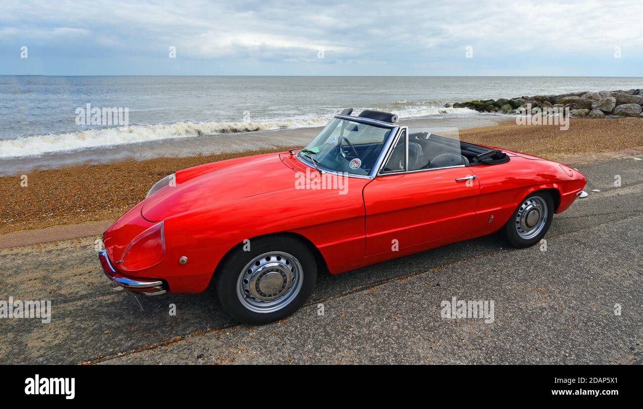 Classic red Alfa Romeo Sports  Convertible Car parked on seafront promenade. Stock Photo