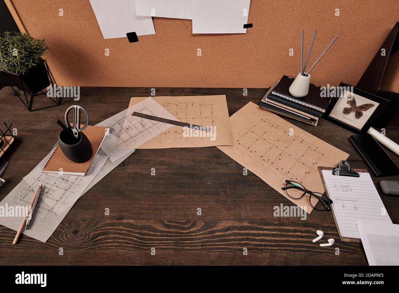Blueprints, copybooks and office supplies surrounding copyspace on wooden table Stock Photo