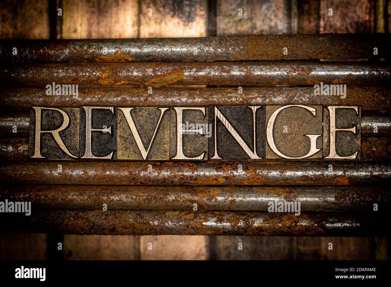 Revenge text message on vintage textured rusty nails over grungy bronze background Stock Photo