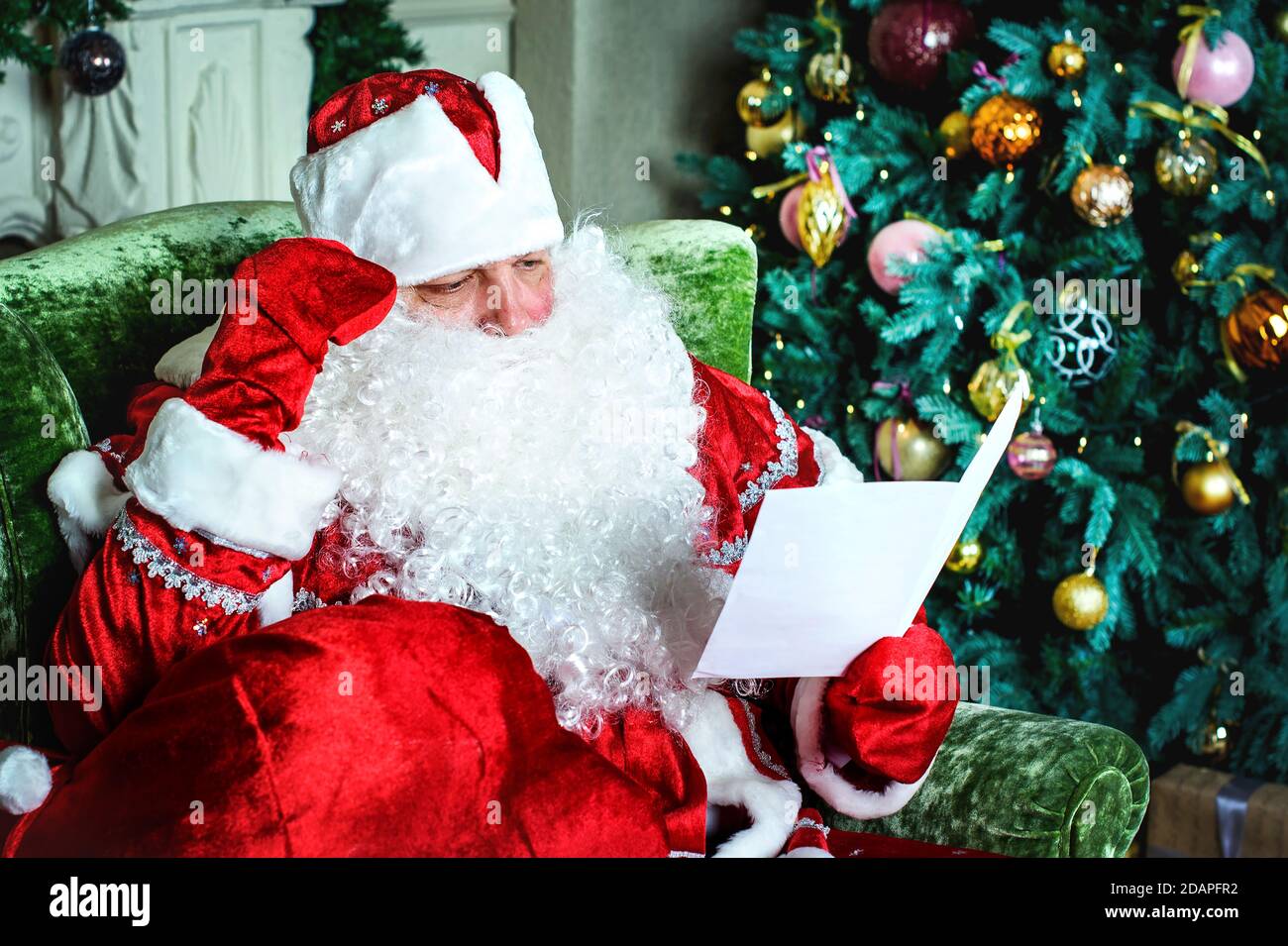 Portrait of Santa Claus reading Christmas letters Stock Photo