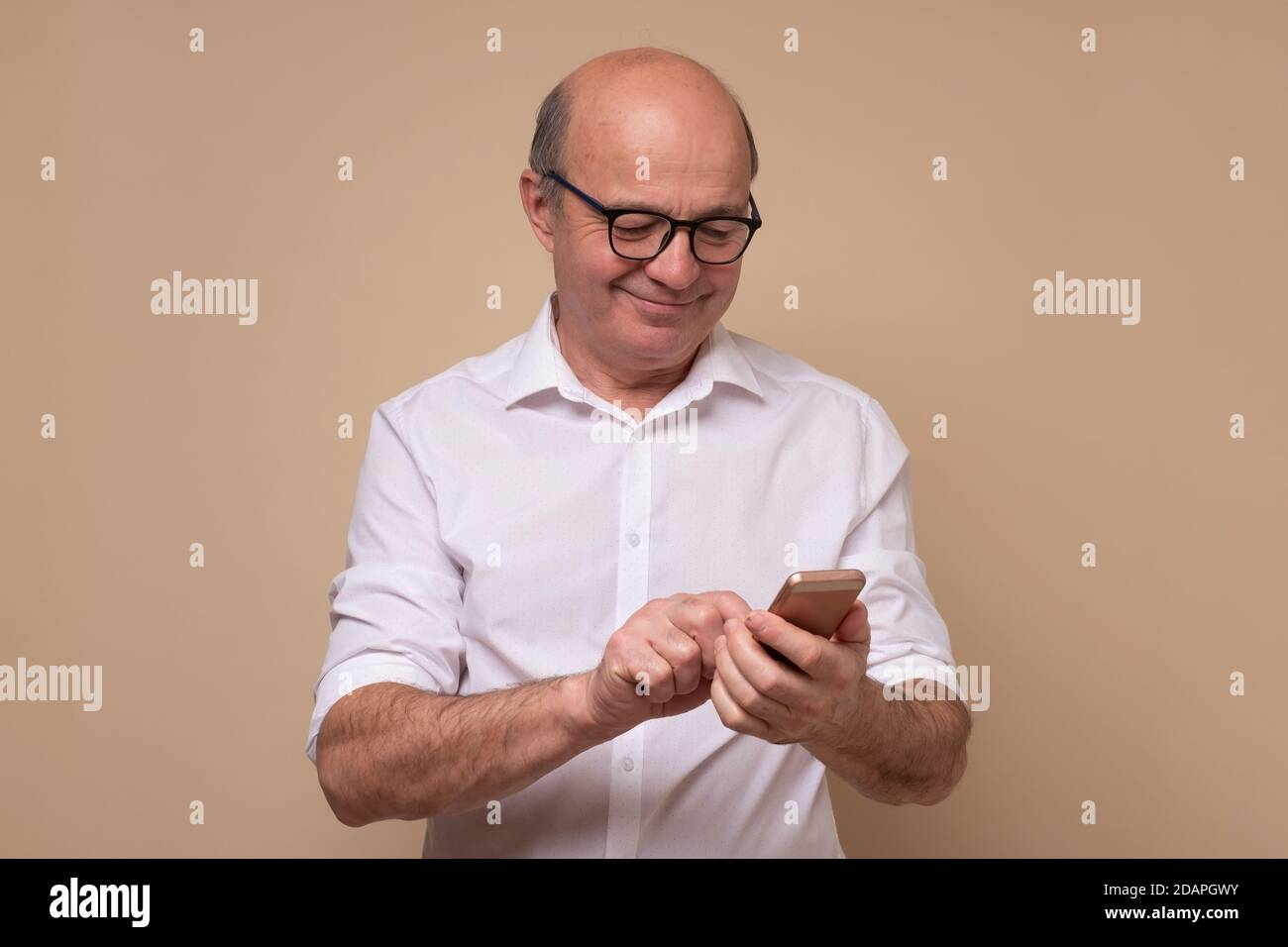 Mature man reading an sms or text message on his mobile Stock Photo