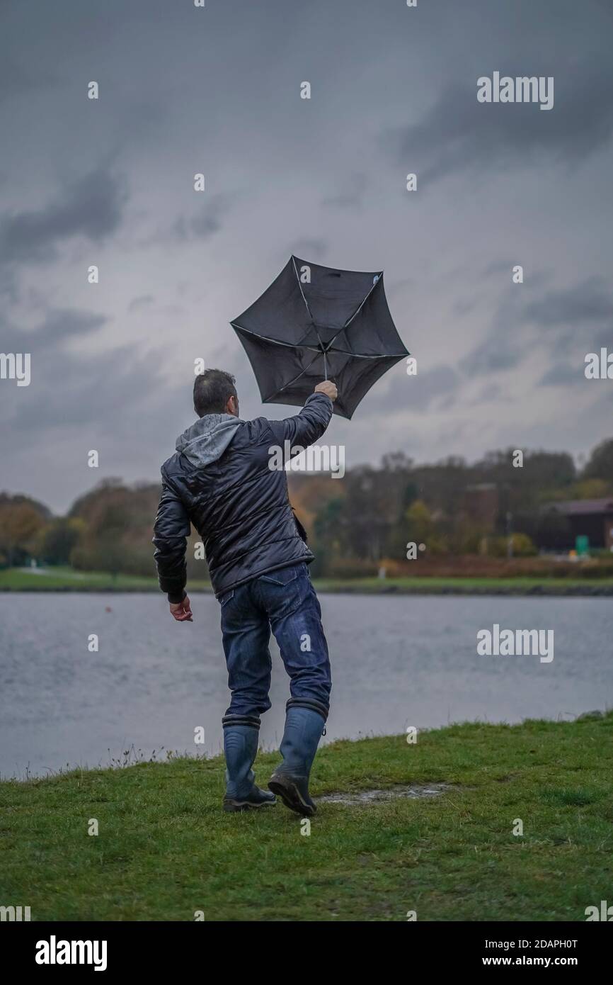 Kidderminster, UK. 14th November, 2020. UK weather: very wet and windy conditions blowing away the walkers at Trimpley reservoir. People struggle to keep their umbrellas from turning inside out. Credit: Lee Hudson/Alamy Live News Stock Photo