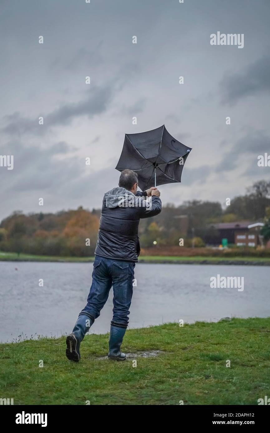 Kidderminster, UK. 14th November, 2020. UK weather: very wet and windy conditions blowing away the walkers at Trimpley reservoir. People struggle to keep their umbrellas from turning inside out. Credit: Lee Hudson/Alamy Live News Stock Photo