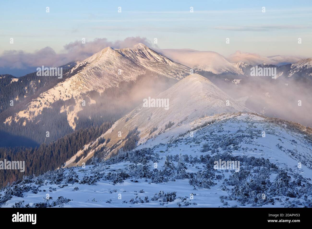 Beautiful landscape on the cold winter day. High mountain with snow white peaks. Snowy background. Stock Photo